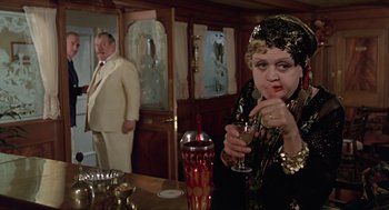 Movie still from “Death on the Nile” (1978), directed by John Guillermin – An older man and a woman in a restaurant; Medium shot, Over the shoulder angle