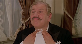 Movie still from “Death on the Nile” (1978), directed by John Guillermin – A person wearing a suit and tie; Close Up shot, Low angle