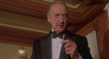 Movie still from “Death on the Nile” (1978), directed by John Guillermin – An older man wearing a tuxedo and a ring; Close Up shot, Low angle