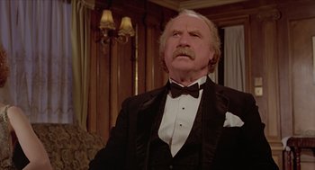 Movie still from “Death on the Nile” (1978), directed by John Guillermin – An older man in a tuxedo looking up at the ceiling; Close Up shot, Low angle