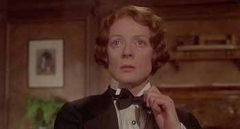 Movie still from “Death on the Nile” (1978), directed by John Guillermin – An older woman wearing a tuxedo and a bow tie; Close Up shot, Low angle