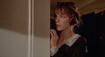 Movie still from “Death on the Nile” (1978), directed by John Guillermin – A woman in a black and white dress looking out of a window; Close Up shot, Low angle