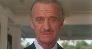 Movie still from “Death on the Nile” (1978), directed by John Guillermin – An older man with a mustache and a mustache on his face; Close Up shot, Low angle
