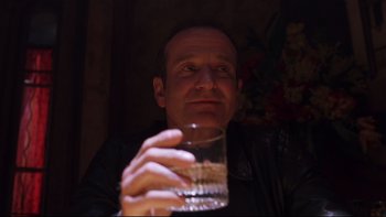 Movie still from “Death to Smoochy” (2002), directed by Danny DeVito – A man holding up a glass of water in a dark room; Close Up shot, Low angle