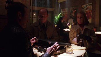 Movie still from “Death to Smoochy” (2002), directed by Danny DeVito – A group of people sitting around a table; Medium shot, Low angle