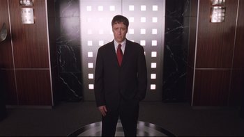 Movie still from “Death to Smoochy” (2002), directed by Danny DeVito – A man in a black suit and red neck tie; Medium shot, Low angle