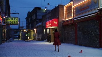 Movie still from “Death to Smoochy” (2002), directed by Danny DeVito – A woman in a red coat walking down a street; Extreme Wide shot, High angle