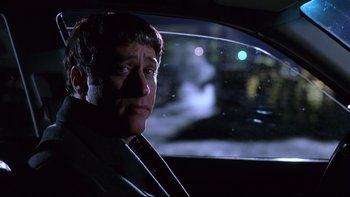 Movie still from “Death to Smoochy” (2002), directed by Danny DeVito – A man sitting in the driver's seat of a car at night; Close Up shot, Over the shoulder angle