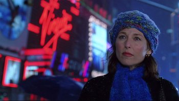 Movie still from “Death to Smoochy” (2002), directed by Danny DeVito – A woman wearing a blue hat and a blue scarf in front of neon lights; Close Up shot, Low angle