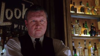 Movie still from “Death to Smoochy” (2002), directed by Danny DeVito – A person wearing a suit and tie; Close Up shot, Low angle