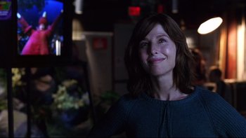 Movie still from “Death to Smoochy” (2002), directed by Danny DeVito – A woman is smiling for the camera in the dark; Close Up shot, Over the shoulder angle