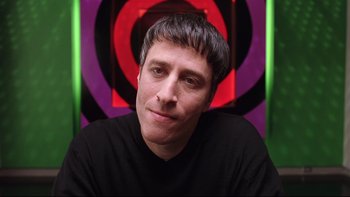 Movie still from “Death to Smoochy” (2002), directed by Danny DeVito – A person wearing a black t - shirt; Close Up shot, High angle