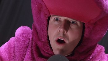 Movie still from “Death to Smoochy” (2002), directed by Danny DeVito – A person wearing a pink blanket and a pink hat; Close Up shot, Low angle