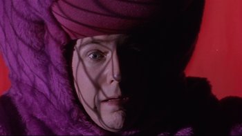 Movie still from “Death to Smoochy” (2002), directed by Danny DeVito – A woman in a purple coat and a purple hat; Close Up shot, Low angle