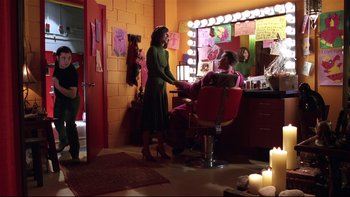 Movie still from “Death to Smoochy” (2002), directed by Danny DeVito – A woman standing in front of a mirror in a room; Wide shot, Over the shoulder angle