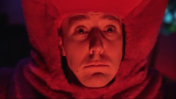 Movie still from “Death to Smoochy” (2002), directed by Danny DeVito – A man in a red hat looking into the camera; Close Up shot, Low angle