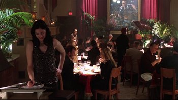 Movie still from “Death to Smoochy” (2002), directed by Danny DeVito – A group of people sitting at a table in a restaurant; Wide shot, Over the shoulder angle