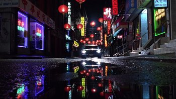 Movie still from “Death to Smoochy” (2002), directed by Danny DeVito – A car driving down a street at night; Wide shot, Low angle