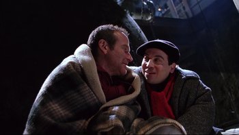 Movie still from “Death to Smoochy” (2002), directed by Danny DeVito – A couple of men sitting next to each other on top of a blanket; Close Up shot, High angle