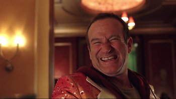 Movie still from “Death to Smoochy” (2002), directed by Danny DeVito – A person with a red jacket smiling; Close Up shot, Low angle