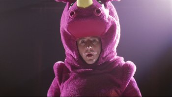 Movie still from “Death to Smoochy” (2002), directed by Danny DeVito – A person wearing a purple rhino costume; Close Up shot, Low angle