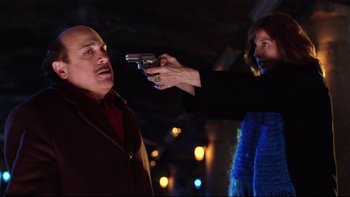 Movie still from “Death to Smoochy” (2002), directed by Danny DeVito – A woman holding a gun up to a man's face; Medium shot, Low angle