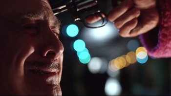 Movie still from “Death to Smoochy” (2002), directed by Danny DeVito – A person holding a gun; Extreme Close Up shot, Low angle