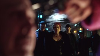 Movie still from “Death to Smoochy” (2002), directed by Danny DeVito – A group of people that are standing in the street; Medium shot, Low angle