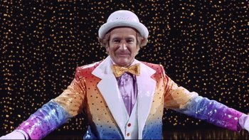 Movie still from “Death to Smoochy” (2002), directed by Danny DeVito – A man wearing a colorful suit and a white hat; Medium shot, Low angle