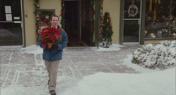 Movie still from “Deck the Halls” (2006), directed by John Whitesell – A man holding a poinsettia plant in his hands; Medium shot, Over the shoulder angle