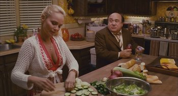 Movie still from “Deck the Halls” (2006), directed by John Whitesell – Two people sitting at a table in a kitchen preparing food; Medium shot, Over the shoulder angle