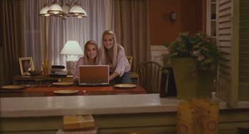 Movie still from “Deck the Halls” (2006), directed by John Whitesell – Two young women sitting at a table with a laptop; Medium shot, High angle