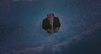 Movie still from “Deck the Halls” (2006), directed by John Whitesell – A man in a suit and tie holding a cane; Extreme Wide shot, Overhead angle