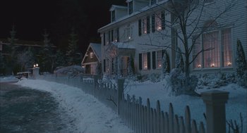 Movie still from “Deck the Halls” (2006), directed by John Whitesell – A white house with a picket fence in front of it at night; Extreme Wide shot, High angle