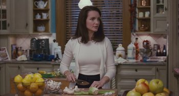 Movie still from “Deck the Halls” (2006), directed by John Whitesell – A woman standing in front of a counter cutting vegetables; Medium shot, Over the shoulder angle