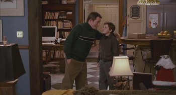 Movie still from “Deck the Halls” (2006), directed by John Whitesell – A man standing next to a young boy in a room; Medium shot, Over the shoulder angle