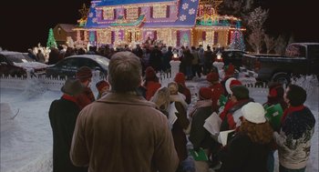 Movie still from “Deck the Halls” (2006), directed by John Whitesell – A group of people standing in front of a house with christmas lights; Extreme Wide shot, Over the shoulder angle
