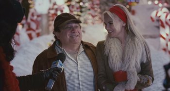 Movie still from “Deck the Halls” (2006), directed by John Whitesell – A man and a woman are standing next to each other holding a microphone; Medium shot, Over the shoulder angle