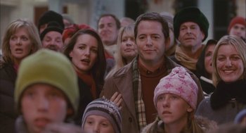Movie still from “Deck the Halls” (2006), directed by John Whitesell – A group of people standing around each other in a crowd; Medium shot, Over the shoulder angle