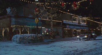 Movie still from “Deck the Halls” (2006), directed by John Whitesell – A snowy street with a bunch of christmas lights hanging above it; Extreme Wide shot, High angle