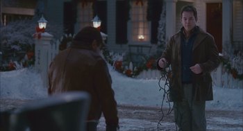 Movie still from “Deck the Halls” (2006), directed by John Whitesell – A man is holding a bunch of lights in his hand; Medium shot, Over the shoulder angle