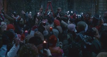 Movie still from “Deck the Halls” (2006), directed by John Whitesell – A group of people standing around with candles on their phones; Wide shot, High angle