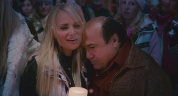 Movie still from “Deck the Halls” (2006), directed by John Whitesell – A man and a woman holding a candle in front of a crowd of onlookers; Close Up shot, Over the shoulder angle
