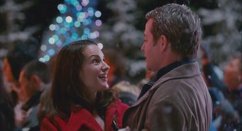 Movie still from “Deck the Halls” (2006), directed by John Whitesell – A man and a woman smiling at each other in front of a christmas tree; Medium shot, Over the shoulder angle
