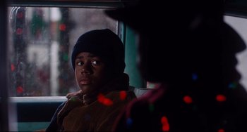 Movie still from “Deep Cover” (1992), directed by Bill Duke – A young boy sitting in a car looking out the window; Close Up shot, Over the shoulder angle