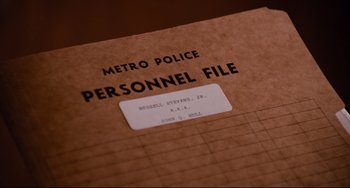 Movie still from “Deep Cover” (1992), directed by Bill Duke – A personnel file with a metro police logo on it; Extreme Close Up shot, Overhead angle