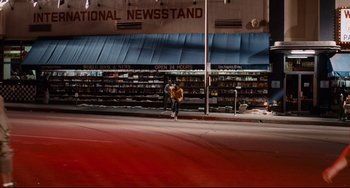 Movie still from “Deep Cover” (1992), directed by Bill Duke – A person riding a skate board down a street; Extreme Wide shot, High angle