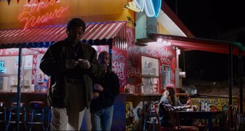 Movie still from “Deep Cover” (1992), directed by Bill Duke – Two people standing in front of a restaurant at night; Wide shot, Low angle