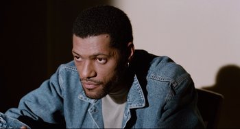 Movie still from “Deep Cover” (1992), directed by Bill Duke – A person wearing a jean jacket; Close Up shot, Over the shoulder angle