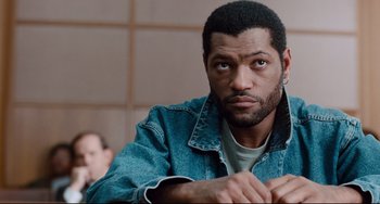 Movie still from “Deep Cover” (1992), directed by Bill Duke – A person wearing a jean jacket; Close Up shot, High angle